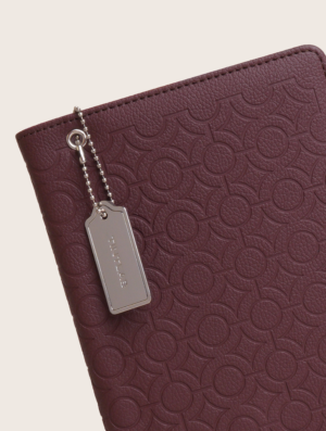 Burgundy textured leather notebook sleeve and Cover, Quran Sleeve and Cover, embossed geometric pattern and a silver metal logo tag with chain